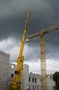 Stationary crane with metal partitions frame tower and concrete counterweight and crane with tilted telescopic jib on site. Royalty Free Stock Photo