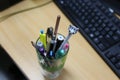 Stationary glass that contain a lot of pens and pencils. Royalty Free Stock Photo