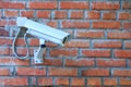 Stationary outdoor video camera of a security video surveillance system on a brick wall