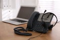 Stationary phone and headset on wooden table indoors. Hotline service Royalty Free Stock Photo