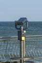 Stationary public beach binoculars on seashore. Coin-operated binocular viewer for tourists