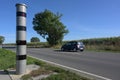 Stationary speed limit enforcement beside a road and a blurred passing car, traffic monitoring with light radar and camera to