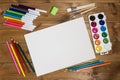 Stationery for children`s creativity on wood background. Sketchbook, colored pencils, paints, felt tips, brushes for drawing. Cop