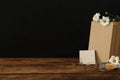 Stationery, glasses and flowers on wooden table near chalkboard, space for text. Teacher`s Day