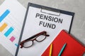 Stationery, glasses, notebook, chart and paper with words PENSION FUND on table Royalty Free Stock Photo