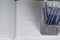 Stationery Holder With Pens On Copybook Sheet.