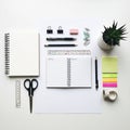 Stationery items on a white surface include an open spiral-bo Royalty Free Stock Photo