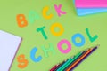 Stationery and multi-colored inscription back to schooll on a green background