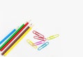 Stationery office supplies, Colored pencils with colorful clips on white background Royalty Free Stock Photo