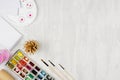 Stationery for painters - paints, palette, brushes, colored pencils, sketchbook on white wooden background, top view, copy space. Royalty Free Stock Photo
