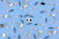 Stationery and puppet eyes are chaotically scattered on a blue background. In the center there is a smiley face made of