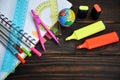 Stationery scattered on a notebook lying on a wooden table