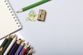 Stationery for school and teaching. Notepad and colored pencils for writing and drawing. Pencil sharpener with pencil shaving. Royalty Free Stock Photo