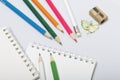 Stationery for school and teaching. Notepad and pencils for writing and drawing. Pencil sharpener with pencil shaving. Royalty Free Stock Photo