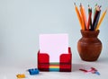 Stationery sheets for notes, pencils in a vase, paper clips and clips for documents on a light background Royalty Free Stock Photo