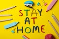 Stationery and Stay at home made of plasticine on yellow background