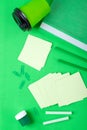 Stationery supplies and paper cup on green