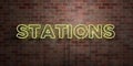 STATIONS - fluorescent Neon tube Sign on brickwork - Front view - 3D rendered royalty free stock picture