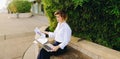 Statistician working outside with laptop and color diagrams. Royalty Free Stock Photo