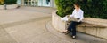 Statistician working outside with laptop and color diagrams. Royalty Free Stock Photo