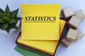 STATISTICS - word on a yellow note paper on a light background with a cactus