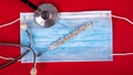 Statoscope thermometer and medical disposable mask on a red background top view close-up. Covid-19 influenza, SARS, measles