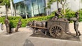 Statue of ancient singapore culture using bullock cart and people discussing on road