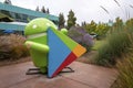 Statue of android with play store logo amidst plants in garden during sunset