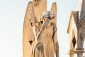 Statue of angel with wings against light sky at cemetery. Closing stoned angel praying in an old cemetery. Graveyard old crying an Royalty Free Stock Photo