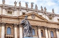 Statue of Apostle Peter in front of St Peter`s Basilica, Rome, Italy. Renaissance sculpture with key on Baroque facade background