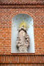 Statue of the ascension of Maria Magdalene in the niche of the brick wall of the building, 1667. Frombork, Poland