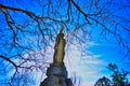 A statue atop a tombstone in Oakland cemetery in Iowa City IA