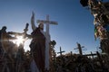 Statue of blessing Jesus Christ against the sun in the famous landmark of Lithuania Hill of Crosses