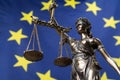 Statue of the blindfolded goddess of justice against an european flag Royalty Free Stock Photo