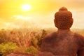 A statue of Buddha against the background of the sunrise in the temple of Borobodur. Java island. Indonesia.