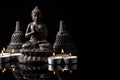 Statue of Buddha sitting in meditation, .candles, With black copy space . Zen and meditation concept