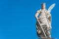 Statue of Catherin with writing bird feather, sword and cartwheel at ancient portal in Magdeburg, Germany, closeup, blue sky Royalty Free Stock Photo