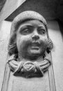 Statue of a child`s head on the entrance wall of an old building