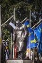 Statue of Churchill in London with bird poop running down his head in front of a flag display