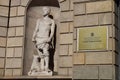 a statue in the corner of a building with a large dog beside it