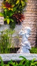 Statue of Cupid in cozy garden. Royalty Free Stock Photo