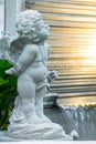 Statue of Cupid in cozy garden. Royalty Free Stock Photo