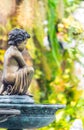 Statue of Cupid in cozy garden. Royalty Free Stock Photo