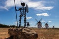 Statue of Don Quixote in La Mancha next to old stone and white windmills. Spain Royalty Free Stock Photo