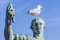 Statue of emperor Caesar Nervae August with gull on the head. Man taking selfie. Humor concept Royalty Free Stock Photo