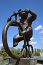 A statue featuring a monkey riding a circus bicycle