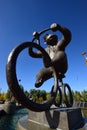A statue featuring a monkey riding a circus bicycle