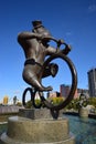 A statue featuring a monkey riding a circus bicycle