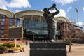 Statue of a football player in front of the Adelaide Oval. People entering the stadium before an Australian football match. Team