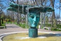 Statue, fountain with face in Greek park Beginning of time, water running down green-blue statue in Odessa, Ukraine
